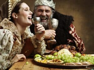 Mead and merriment. A mature king feasting alone over great easy mead recipe in a banquet hall.