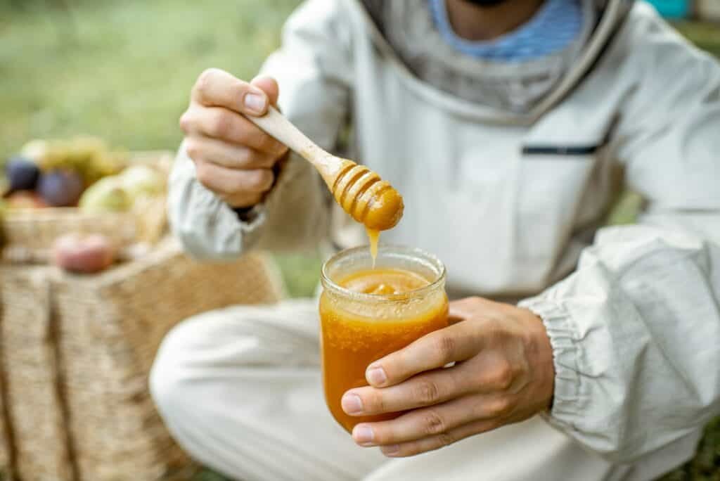 Beekeeper tasting honey outdoors