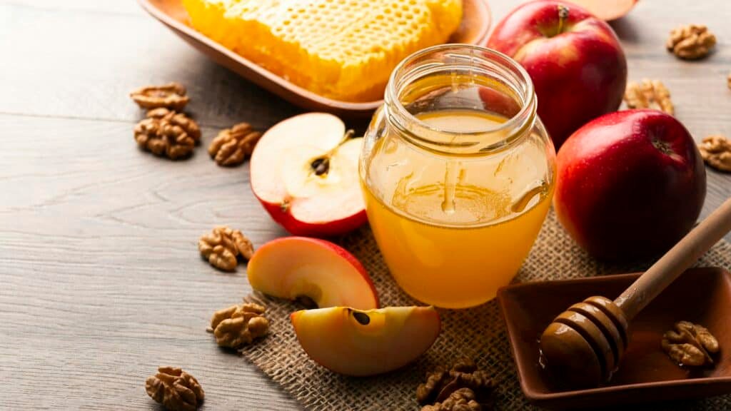 what is a cyser mead - flavors of honey, honey dipper, honeycomb, red apples and walnuts on kitchen table