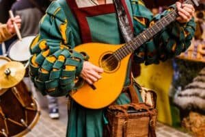 Medieval troubadour playing an antique guitar at mead festivals