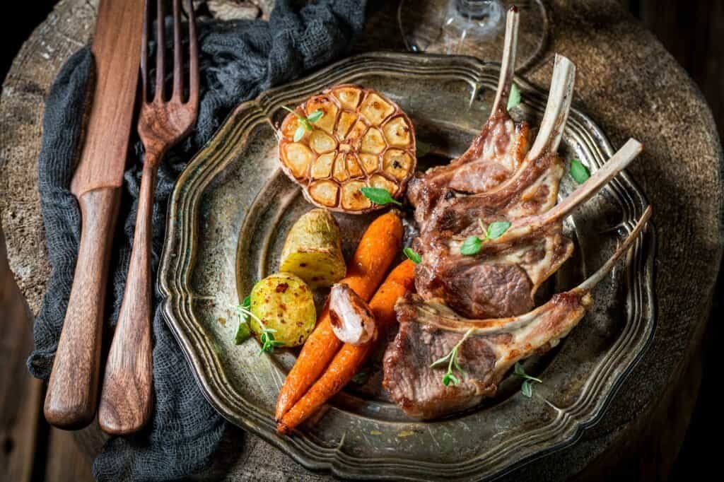 Closeup of roasted ribs of lamb with vegetables